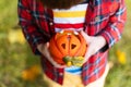 Kid`s hand holding Jack`O pumpkin lamp, trick or treat on Halloween day. Concept for autumn holidays background Royalty Free Stock Photo
