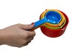 Kid`s hand holding the set of colorful plastic measuring spoons Royalty Free Stock Photo