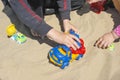 Kid`s hand playing with a toy truck in the sand Royalty Free Stock Photo