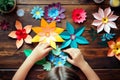 A kid\'s handmade delight: crafting colorful paper flowers, top view