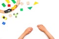 Kid`s hands and colorful toys. Fidget spinner, cars, toy train, bricks and blocks on white background Royalty Free Stock Photo