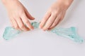 Kid`s hands holding a transparent green slime isolated