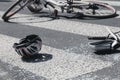 Helmet and broken cars mirror next to broken bicycle on pedestrian crossing