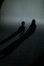 kid's shadows on wall. shadow of two children, boy and girl on striped gray black white wall