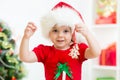 Kid in Santa hat holding Christmas cookies Royalty Free Stock Photo