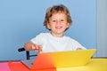 Kid at school with notebook. Child is ready to answer with a blackboard on a background. Funny little child having fun