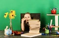 Kid and school supplies, green background. Girl with bored face Royalty Free Stock Photo