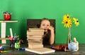 Kid and school supplies, green background. Girl with bored face Royalty Free Stock Photo