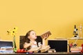 Kid and school supplies on yellow wall background Royalty Free Stock Photo