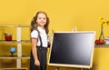 Kid and school supplies on yellow wall background Royalty Free Stock Photo