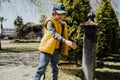 Kid schoolboy in casual clothing washing his hands in the street old fashioned drinking water fountain. Boy in blue Royalty Free Stock Photo