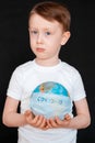 Kid in Self isolation looking at globe learning about Covid-19 Coronavirus from home, Child with curious face thinking Royalty Free Stock Photo
