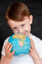 Kid in Self isolation looking at globe learning about Covid-19 Coronavirus from home, Child with curious face thinking about the Royalty Free Stock Photo