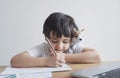 Kid in self isolation siting with notebook on table doing homework,Happy Child boy writing or drawing on white paper, Elementary Royalty Free Stock Photo