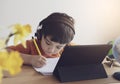 Kid self isolation using tablet for his homework, Child doing  using digital tablet searching information on internet while school Royalty Free Stock Photo