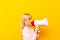 Kid shouting through megaphone. Communication concept. yellow background as copy space for your text Royalty Free Stock Photo