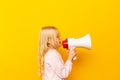 Kid shouting through megaphone. Communication concept. yellow background as copy space for your text Royalty Free Stock Photo
