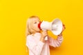 Kid shouting through megaphone. Communication concept. yellow background as copy space for your text Royalty Free Stock Photo