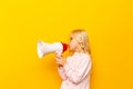 Kid shouting through megaphone. Communication concept. yellow background as copy space for your text Royalty Free Stock Photo