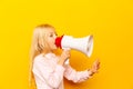 Kid shouting through megaphone. Communication concept. yellow background as copy space for your text Royalty Free Stock Photo