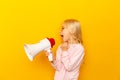 Kid shouting through megaphone. Communication concept. yellow background as copy space for your text Royalty Free Stock Photo