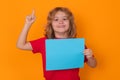 Kid showing blank banner on yellow background, pointing finger up. Advertising billboard, placard. Child hold empty