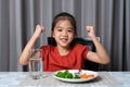 Kid shows strength of eats vegetables and nutritious food