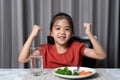 Kid shows strength of eats vegetables and nutritious food