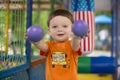 Kid shows toy balls. Child plays in the children`s center Royalty Free Stock Photo