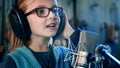 Kid singing in studio.Little girl singing a song.Front view close up. Kid wearing headphones attending singing class. Royalty Free Stock Photo