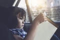 Kid siting on car seat and reading a book, Little boy sitting in the car in child safety seat, Portrait of toddler entertaining Royalty Free Stock Photo