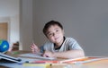 Kid siting on table doing art and craft for school homework, Child boy holding colour pen drawing or painting on white paper, Royalty Free Stock Photo