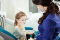 Kid sits at dentist office and holds cheek