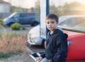 Kid sitting at bus stop waiting for School bus.Portrait young boy looking at camera with thinking face, School child sitting Royalty Free Stock Photo