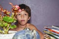 Kid sitting on chair with table against lilac wind television wall