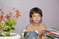 Kid sitting on chair with table against lilac wind television wall