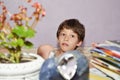 Kid sitting on chair with table against lilac wind television wall