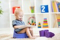 Kid sitting on chamber pot playing tablet pc Royalty Free Stock Photo