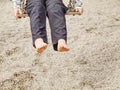 Kid sitting with feet against a sand in summer playground Royalty Free Stock Photo