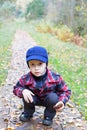 Kid sitting forest road fall season