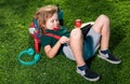 Kid sitting on grass with tablet in the park. Outdoor school. Smiling boy hold tablet computer. School, education Royalty Free Stock Photo