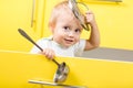 Kid sitting inside yellow opened kitchen box with