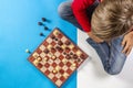 Kid sitting near chessboard and play chess game Royalty Free Stock Photo