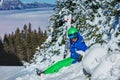 Kid with ski helmet and googles hold skies smile sit in snow Royalty Free Stock Photo