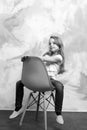 Kid or small smiling girl sitting on orange chair Royalty Free Stock Photo