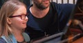 Kid smiling during piano class with teacher.Kid learning to play piano from teacher.Little girl learning piano lesson Royalty Free Stock Photo