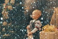 Kid in snow. Funny kid holding Christmas gift. Babies. Merry Christmas and Happy Holidays. Christmas tree decoration Royalty Free Stock Photo