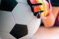 Kid soccer goalkeeper hand catching a football closed up shot