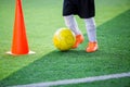 Kid soccer player control ball around cone maker for soccer training Royalty Free Stock Photo