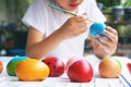 Kid painting easter egg with vibrant color Royalty Free Stock Photo